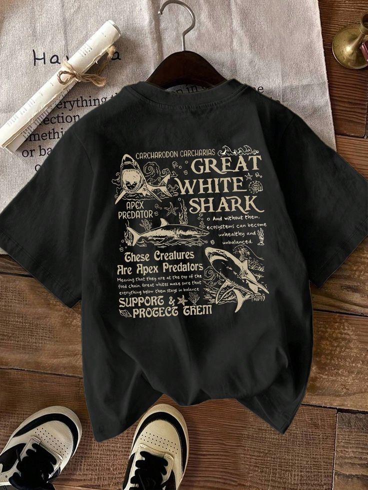 Black graphic shark print t-shirt laid on a wooden table